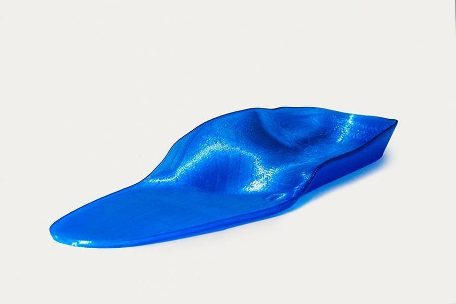 Orthopädische Einlage aus glänzendem blauen Material 3D gefertigt, im Halbprofil, die Spitze weist nach links unten.