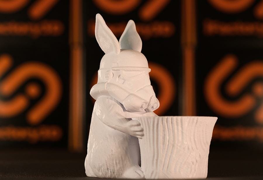 Hasenfigur mit Gasmaske vor einem Baumstumpf, 3D gedruckt in weißem PLA Filament.