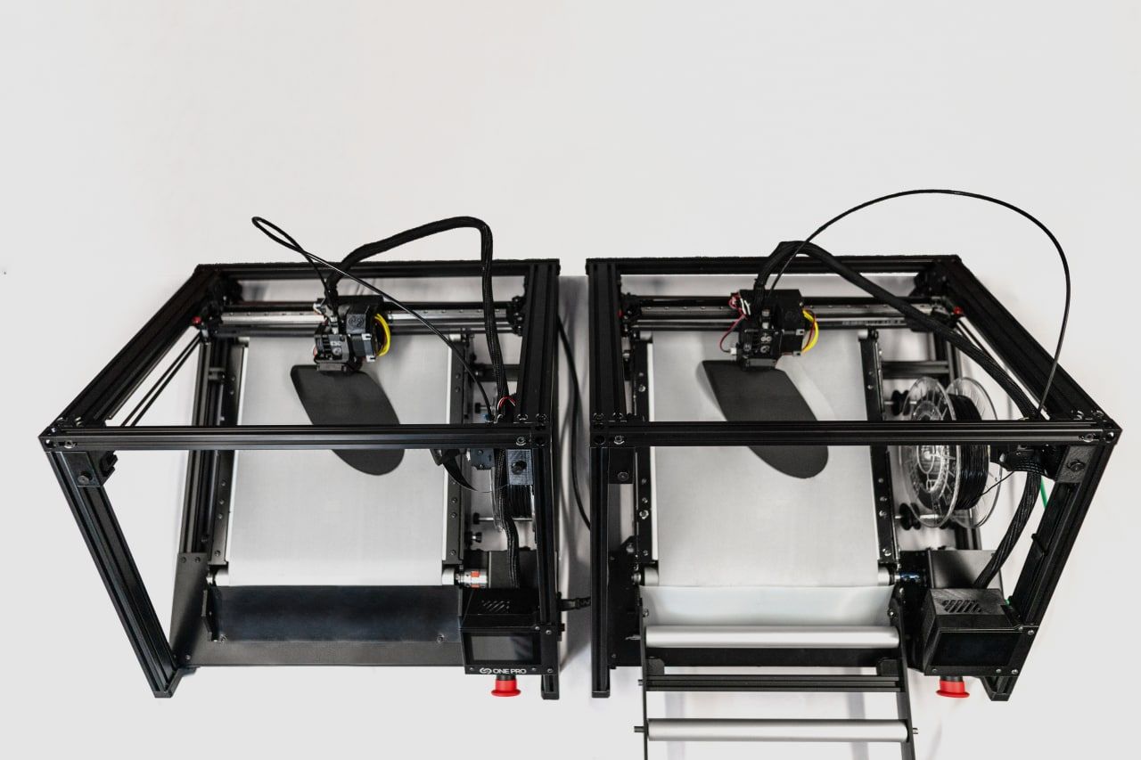 showing 2 3D belt printers side by side from above, both printing insoles simultaneously