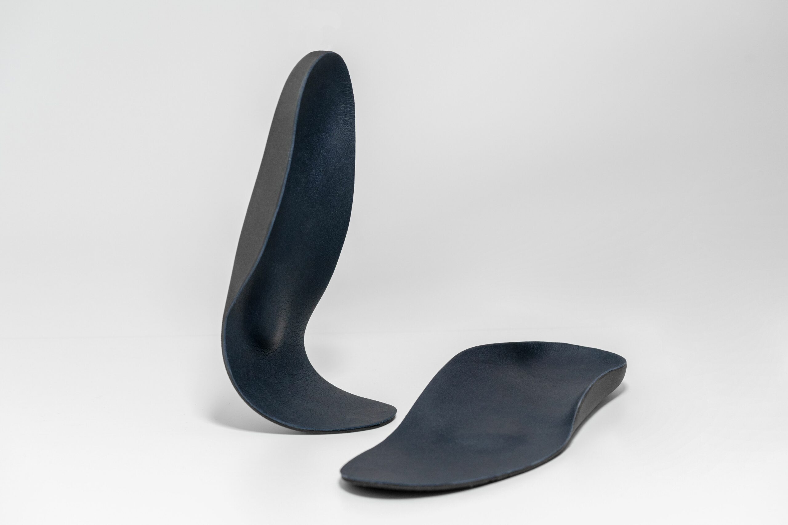 pair of insoles with one bending to show flexibility of material