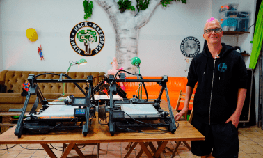 Founder of the xHain Hack and Makespace next to the belt printers of iFactory3D. In the video, he will explain what the Berlin-based maker space is all about.
