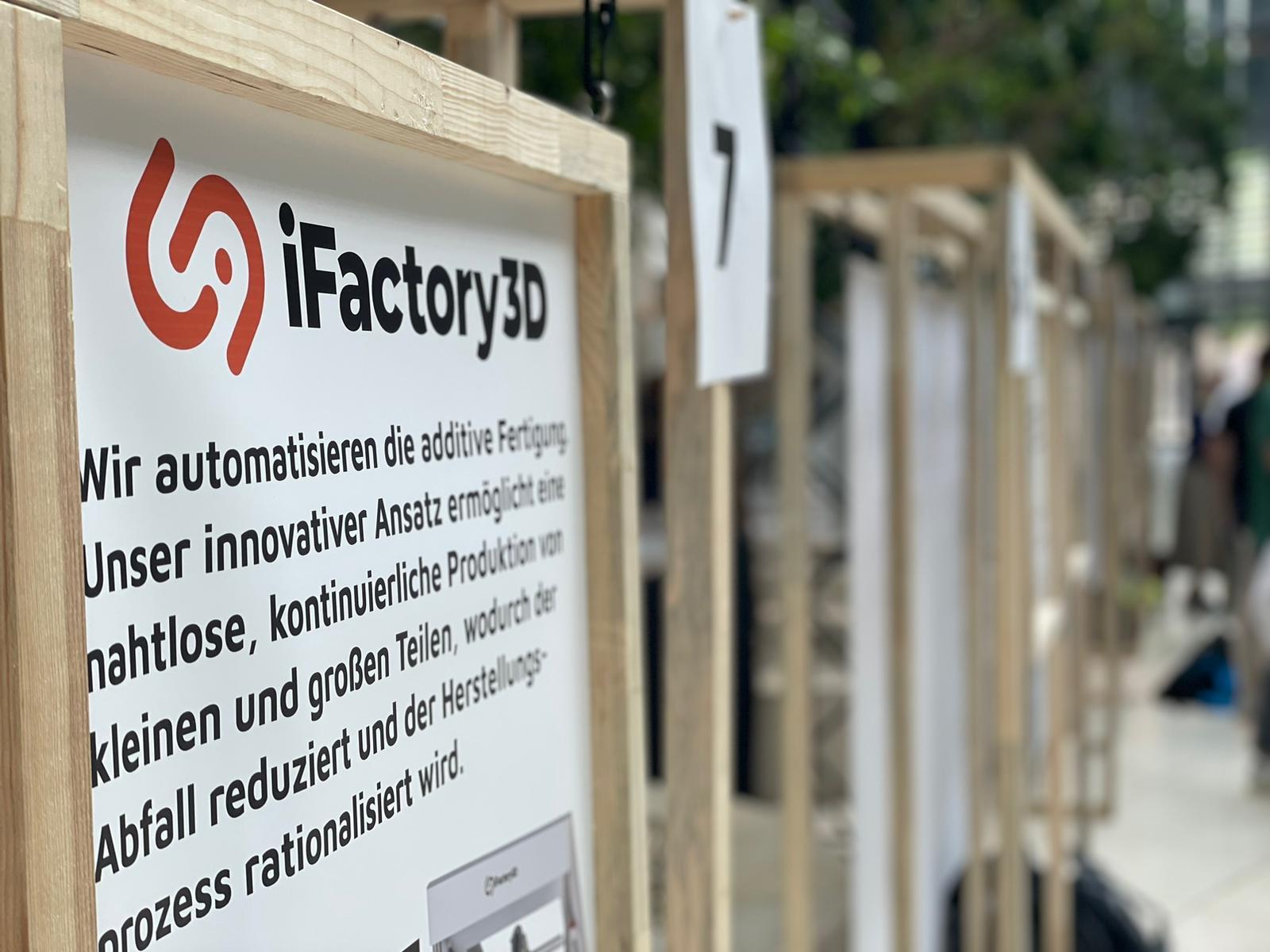 Sign (with German text) by iFactory3D at a trade fair in a green setting with natural and sustainable materials