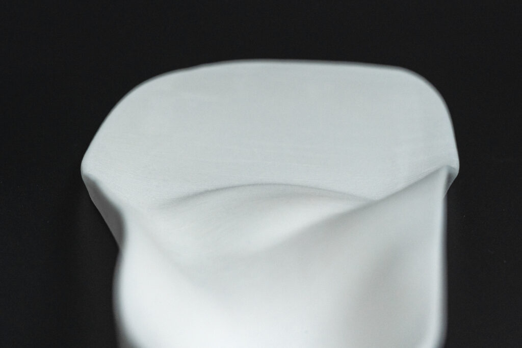 Eine 3D-gedruckte weiße Einlegesohle von der Ferse aus flach Richtung Ballen fotografiert, entstanden mittels 3D-Druck von iFactory3D für orthopädische Einlagen
